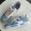 Pair of blue and white sneakers on a round stone surface